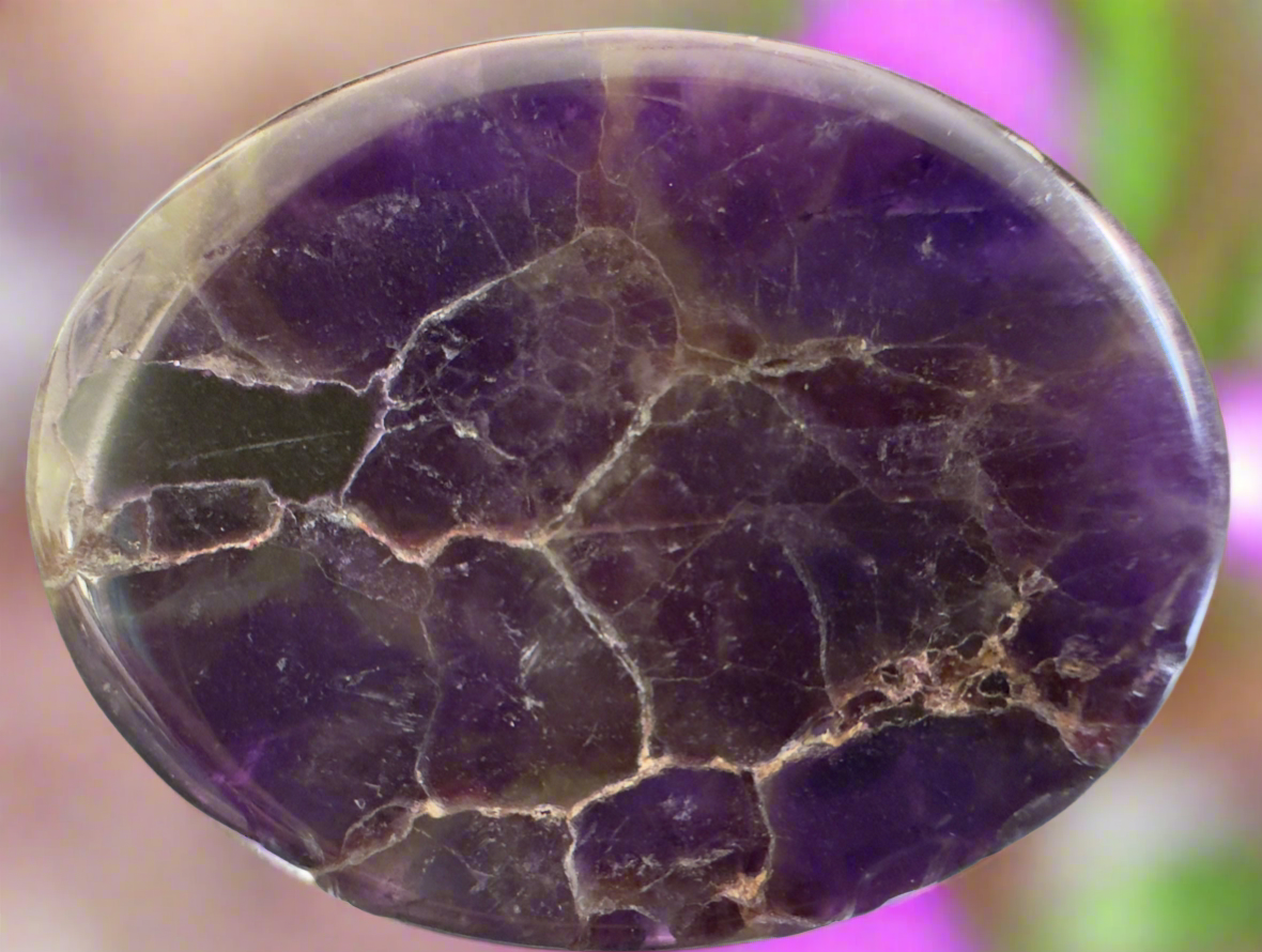 Close-up of an amethyst cabochon with cracked surface.