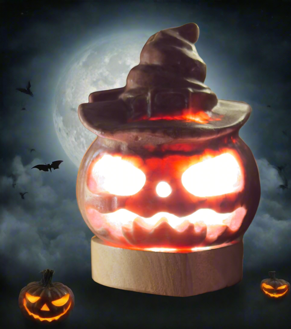 Halloween-themed decorative jack-o'-lantern with a witch's hat, lit up against a full moon backdrop with bats and two additional jack-o'-lanterns at the base.