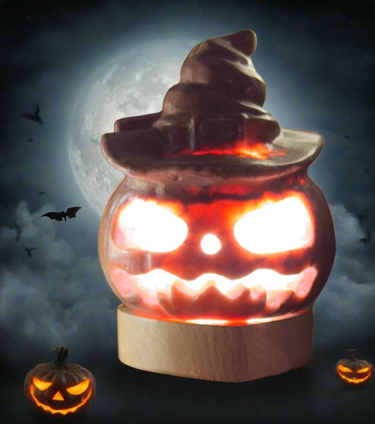 Halloween-themed decorative jack-o'-lantern with a witch's hat, lit up against a full moon backdrop with bats and two additional jack-o'-lanterns at the base.