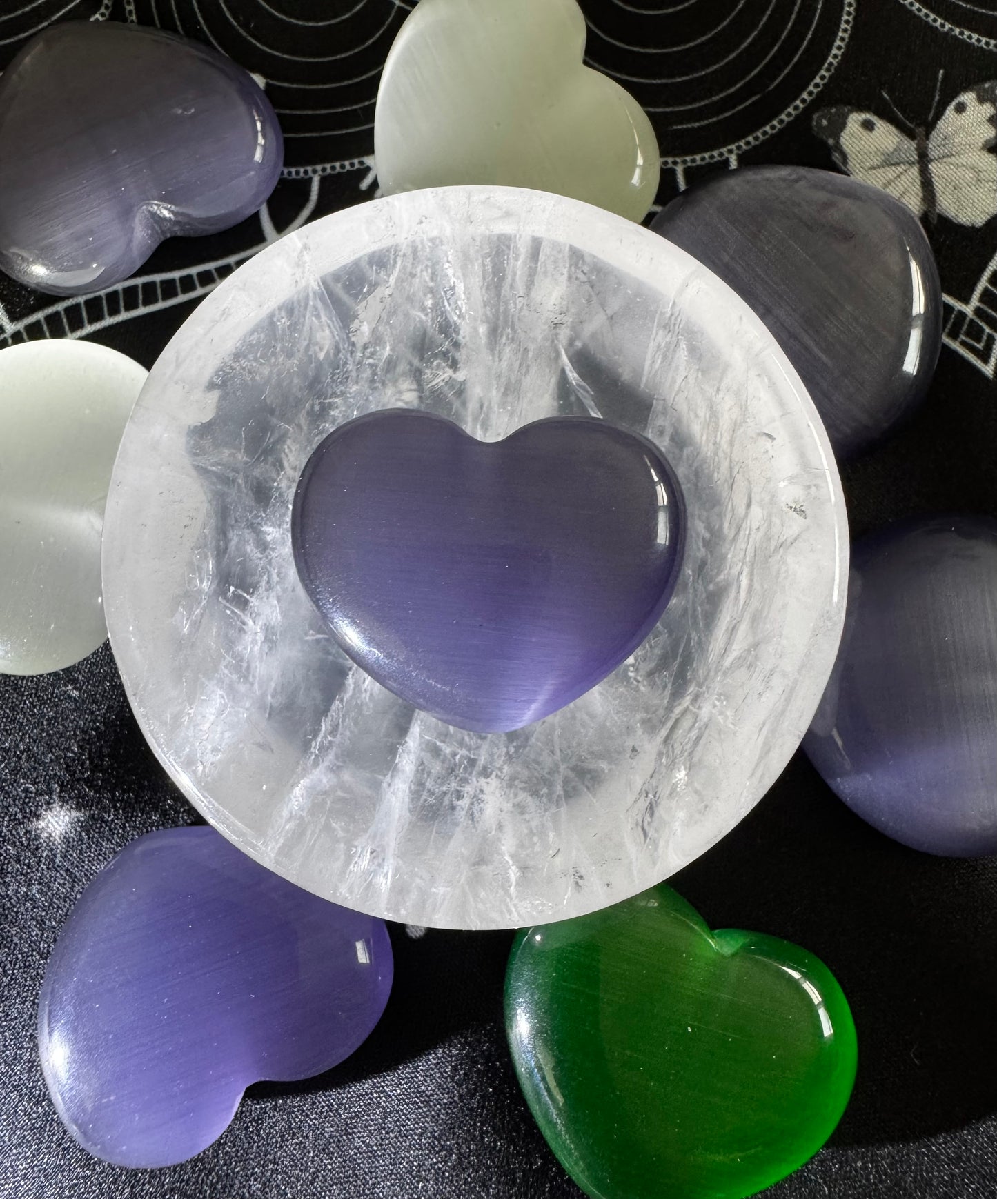 Selenite bowl with purple, green, and white heart-shaped crystals.