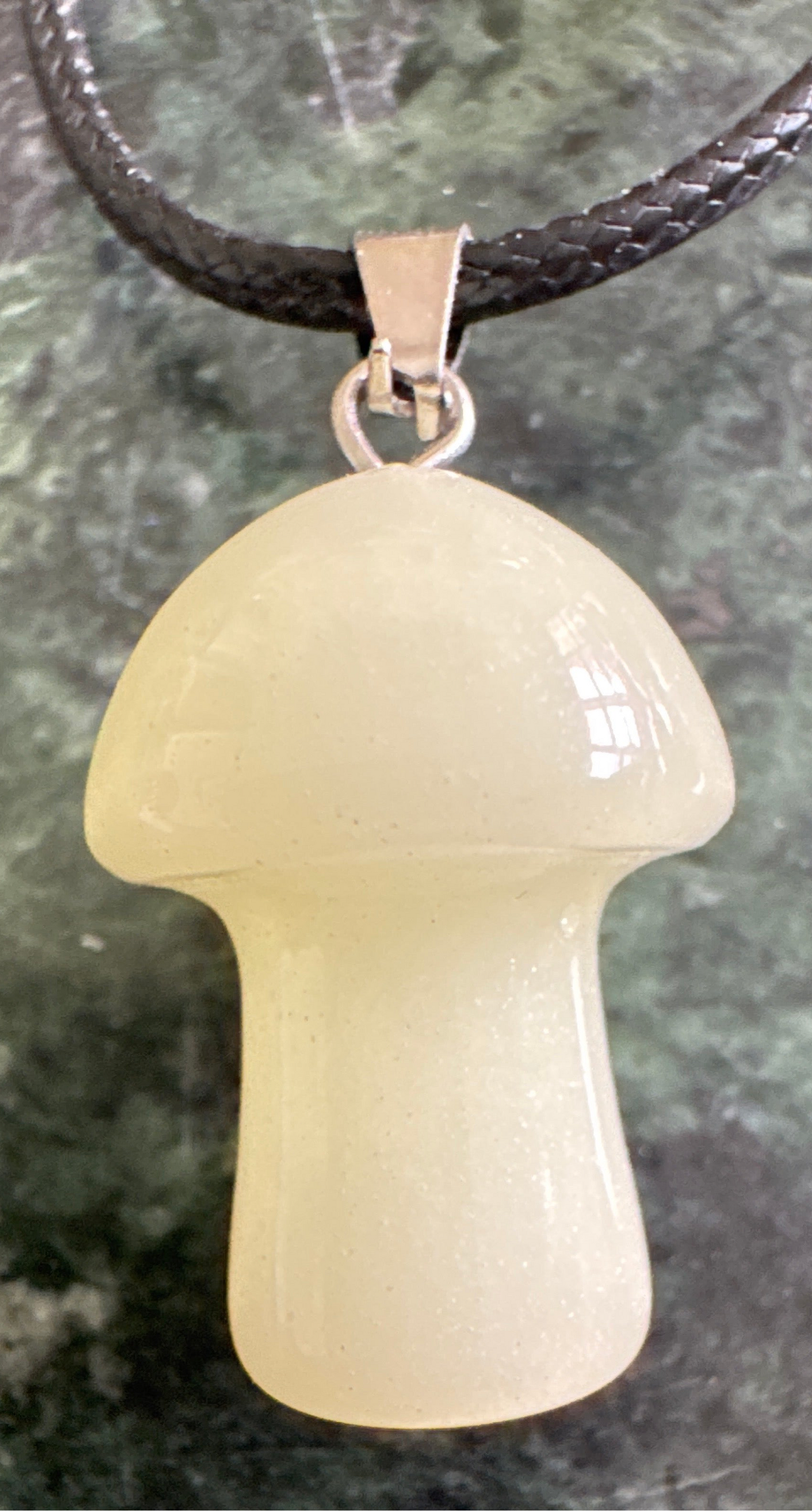 Mushroom-shaped pendant on a black cord.