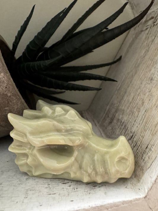 Stone dragon head figurine, with an artificial plant and pot.