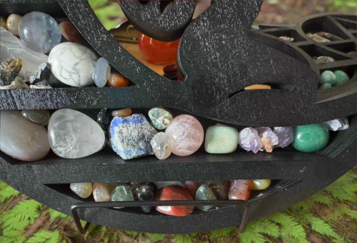 Close-up of a black wooden shelf filled with various colorful stones and crystals.