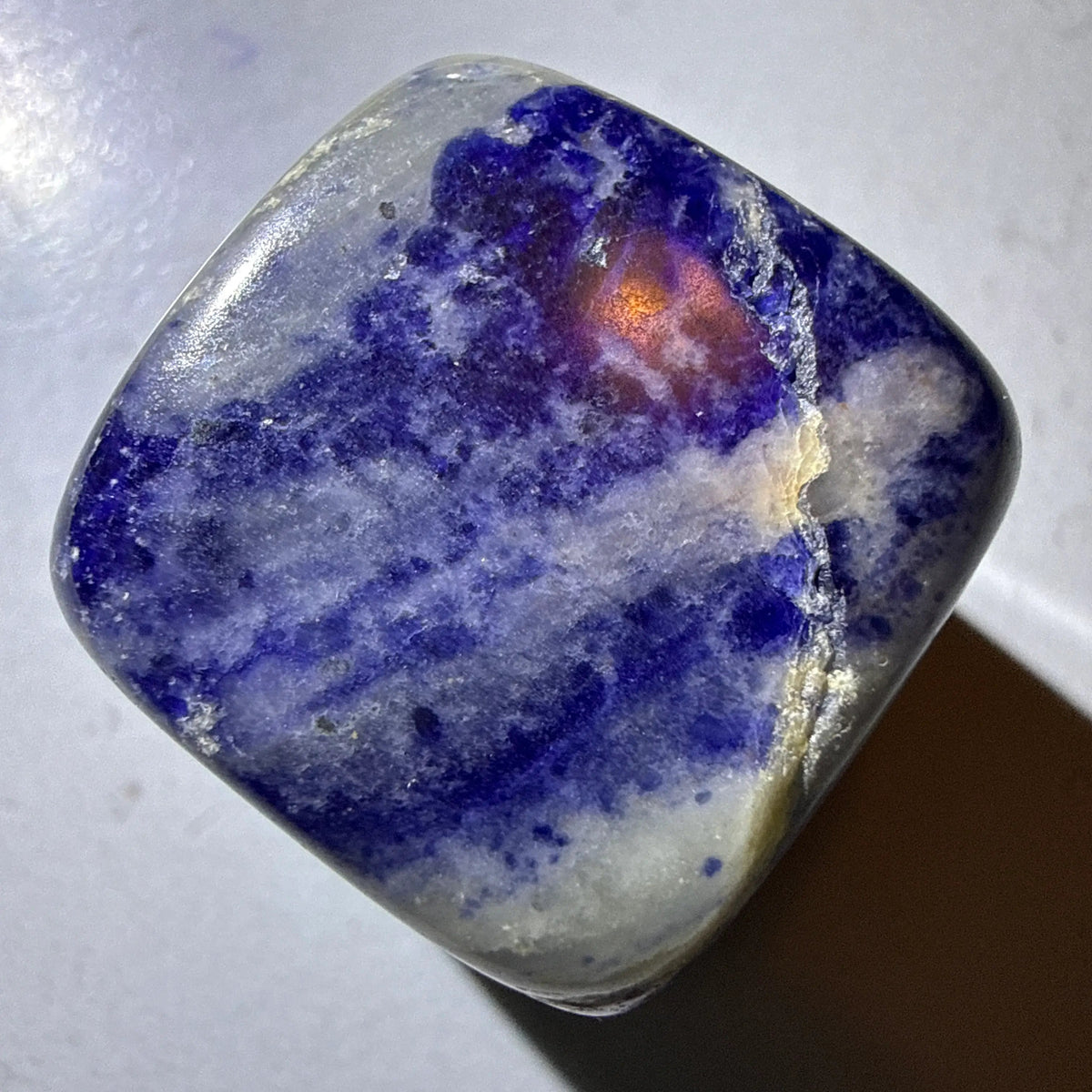 close up of a summer sodalite carved cube with a natural fracture