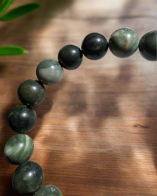Close up of a 9 mm serpentine bead elastic band bracelet on a wooden table