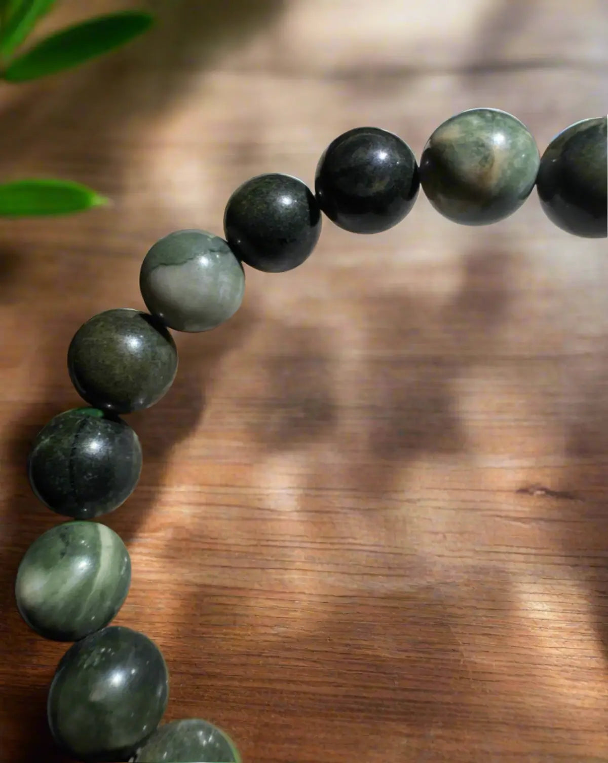 Serpentine 9mm elastic bead bracelet on wooden table