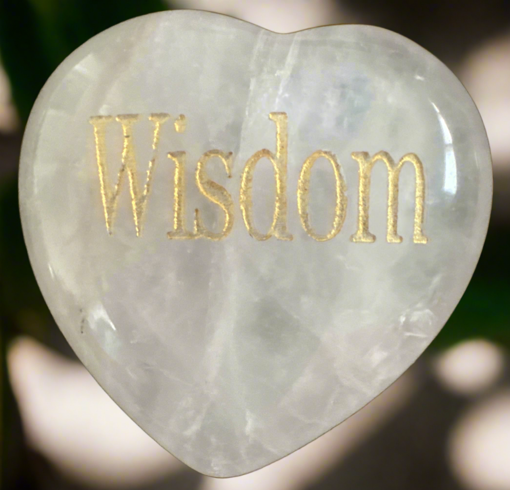 Heart-shaped white gemstone with the word "Wisdom" engraved in gold.