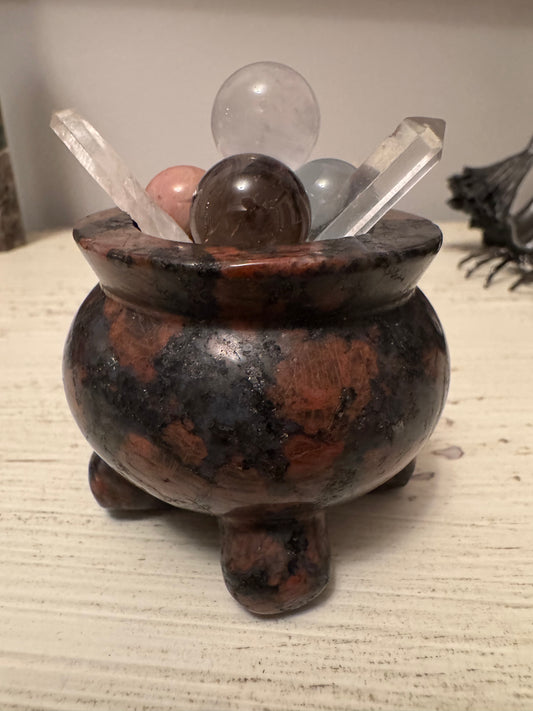 Stone cauldron filled with assorted crystal spheres and points.