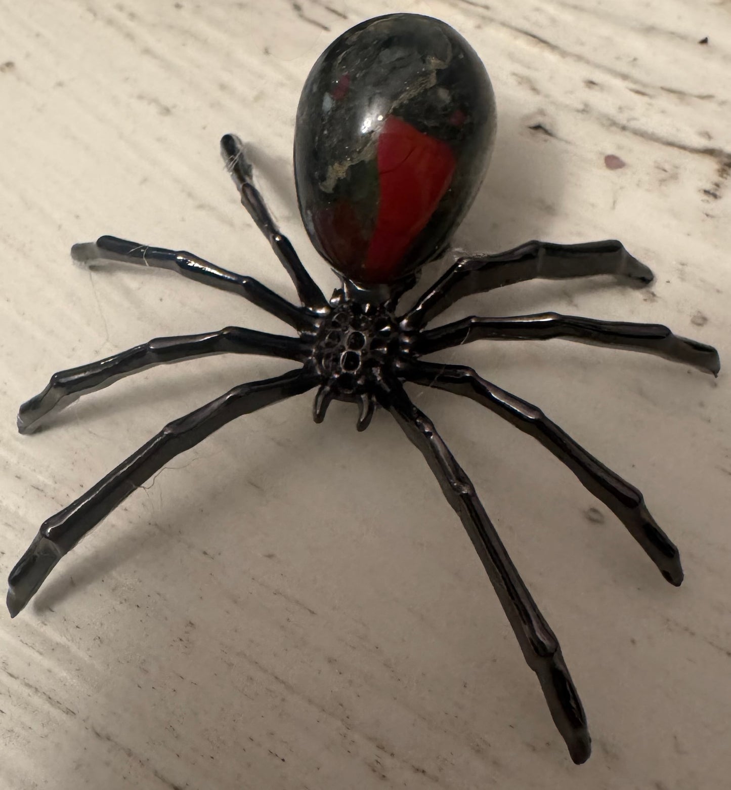 Black spider with red marking on abdomen.