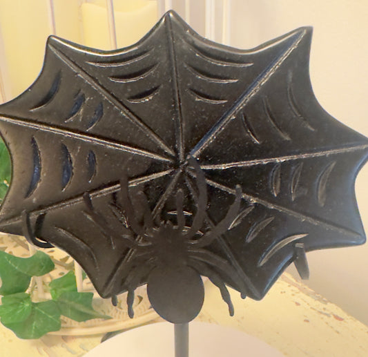 Close up of black obsidian carved spider web on a black metal stand