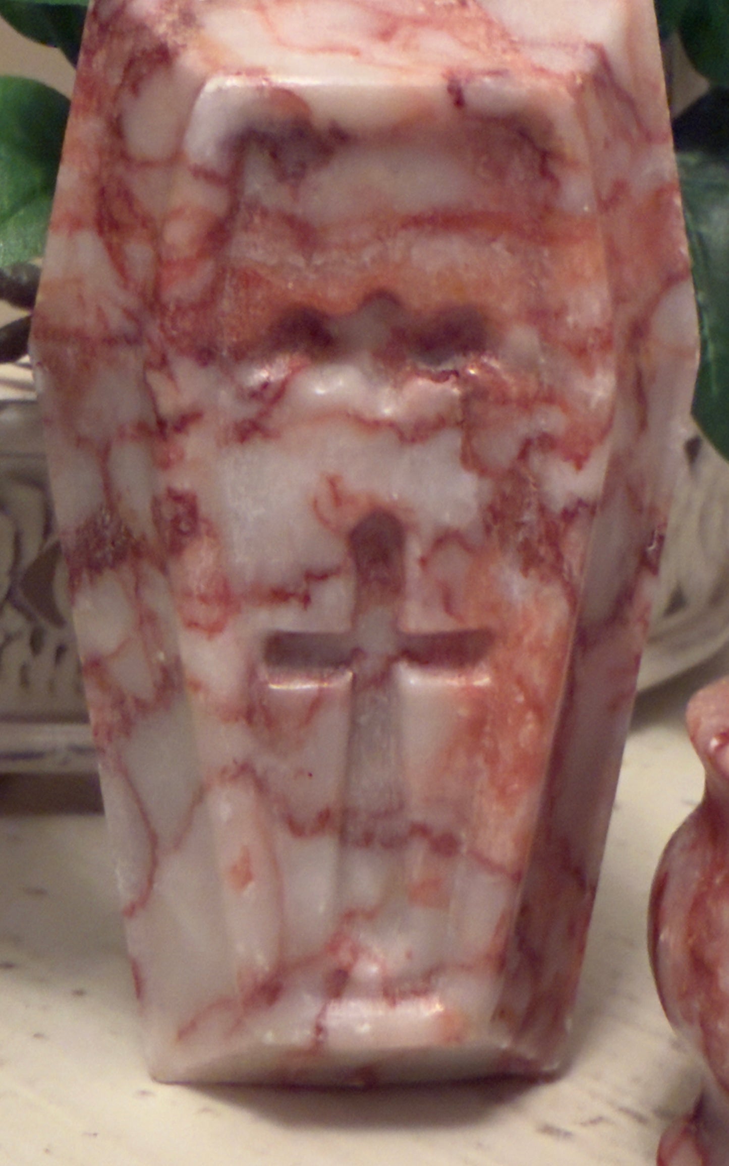 Red and white marbled stone carving of a cross.