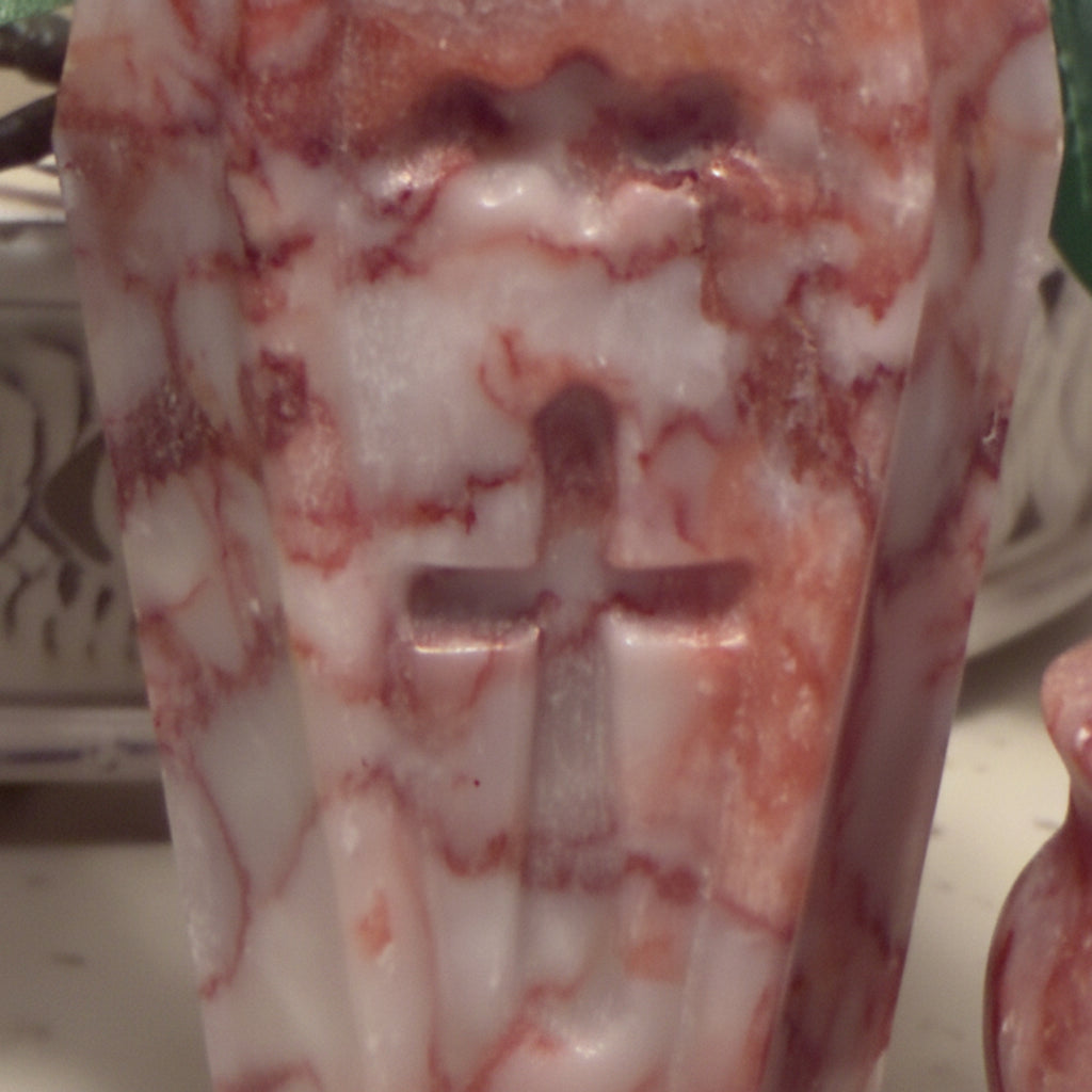 Red and white marbled stone carving of a cross.
