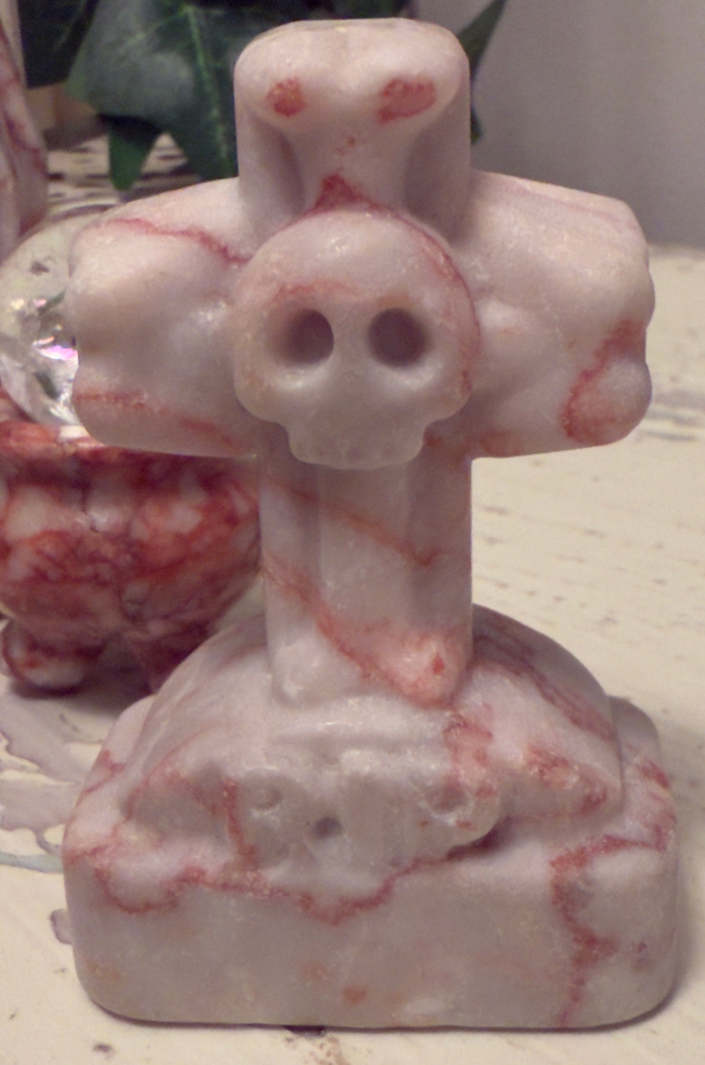 Marble sculpture of cross with skull.