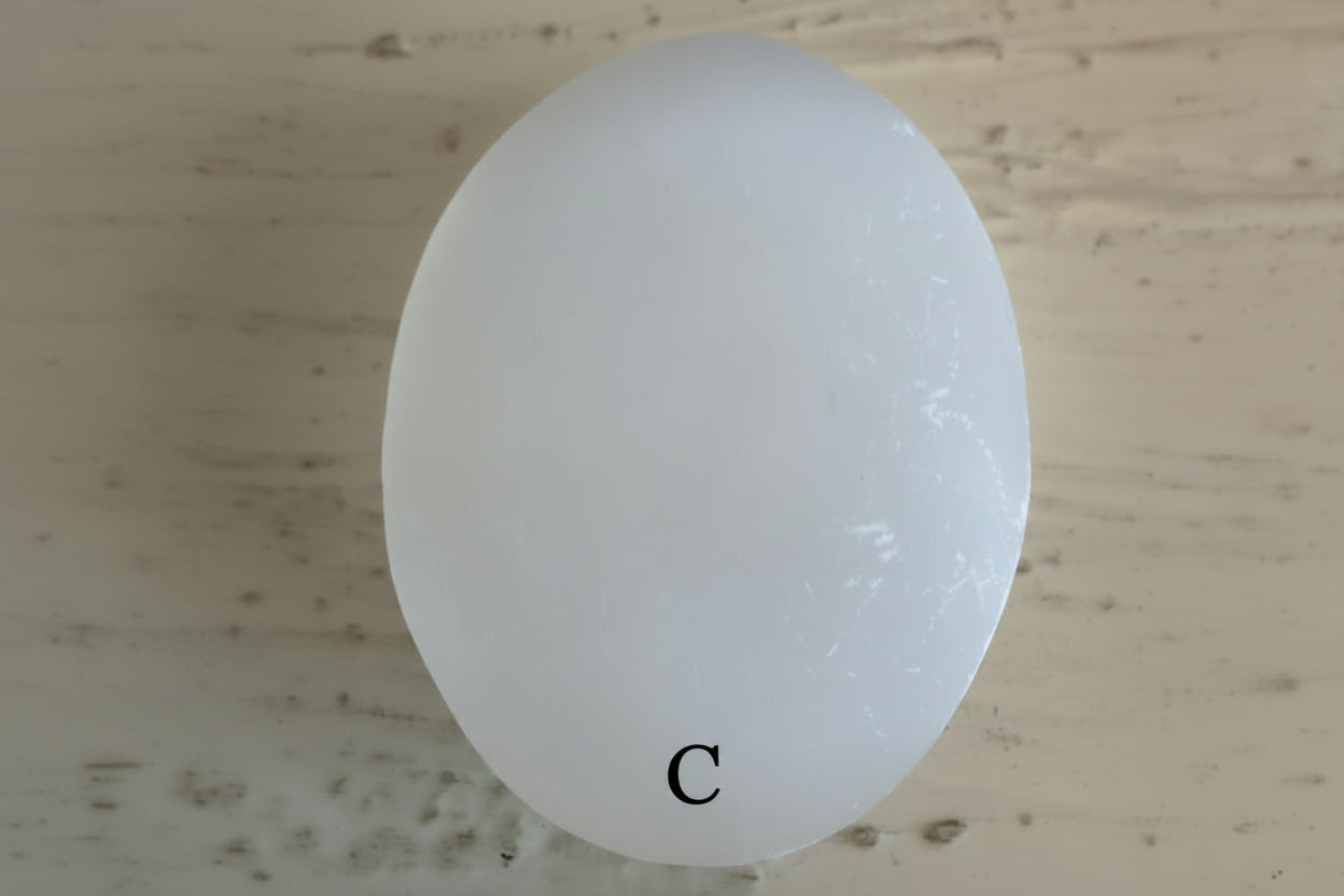 Selenite Palm Stone with a muted background marked as specimen C