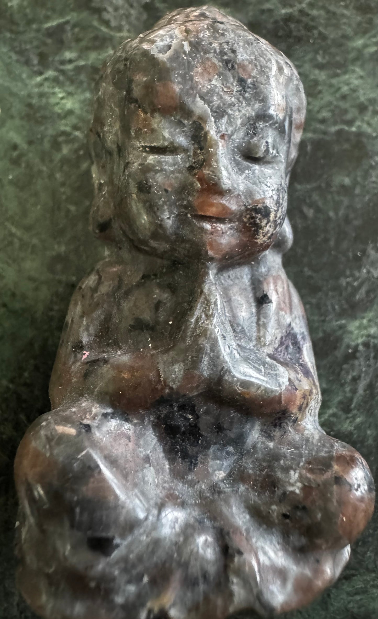 Stone Buddha statue in seated meditative pose.