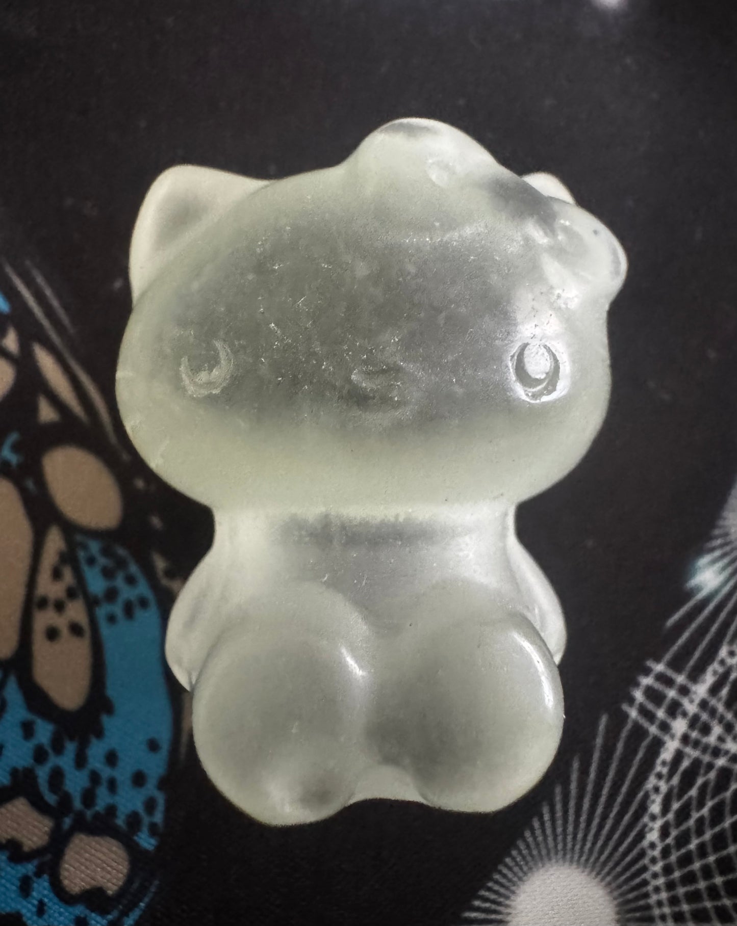 Pale green, translucent Hello Kitty figurine.