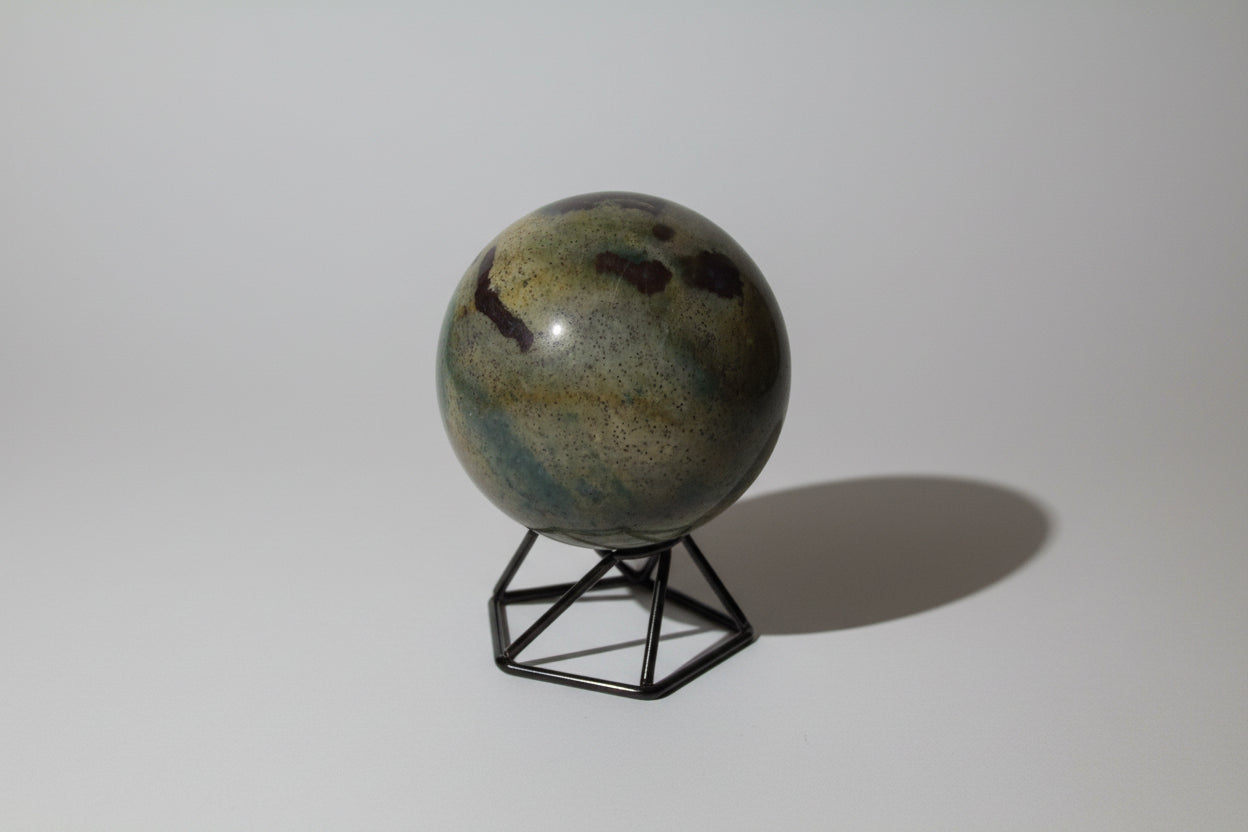 polychrome jasper sphere light green and yellows with some dark brown and tiny spots on a stand with no background