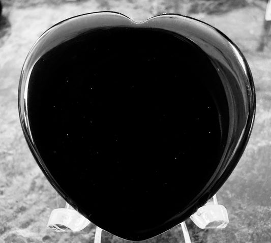 Black heart-shaped obsidian on clear plastic stand.