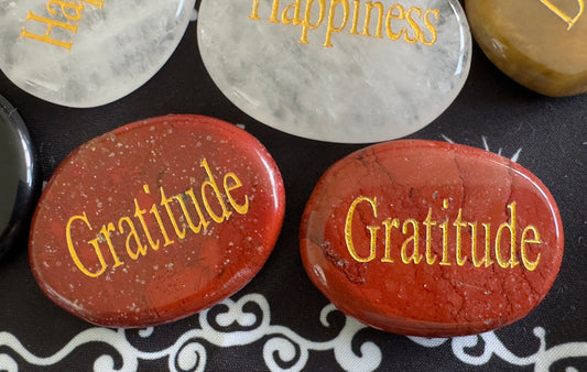 Red and white rocks with gold lettering spelling out positive words.