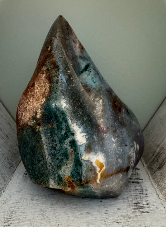 Polished ocean jasper stone in a white wooden nook.