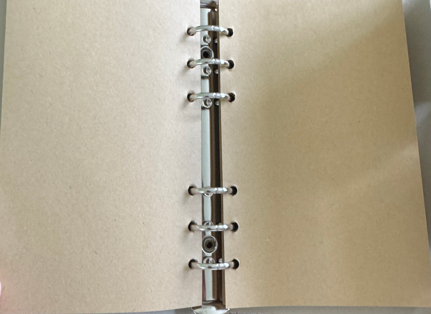 Open notebook with tan paper and metal rings.