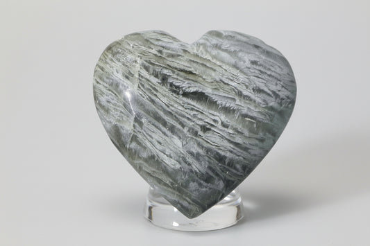 thousand layer garden quartz carved heart in a glass stand