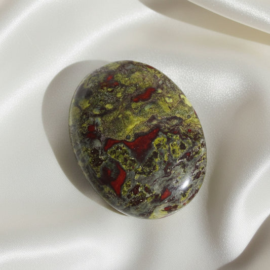 pretty close up of green, red brown dragons blood crystal polished stone