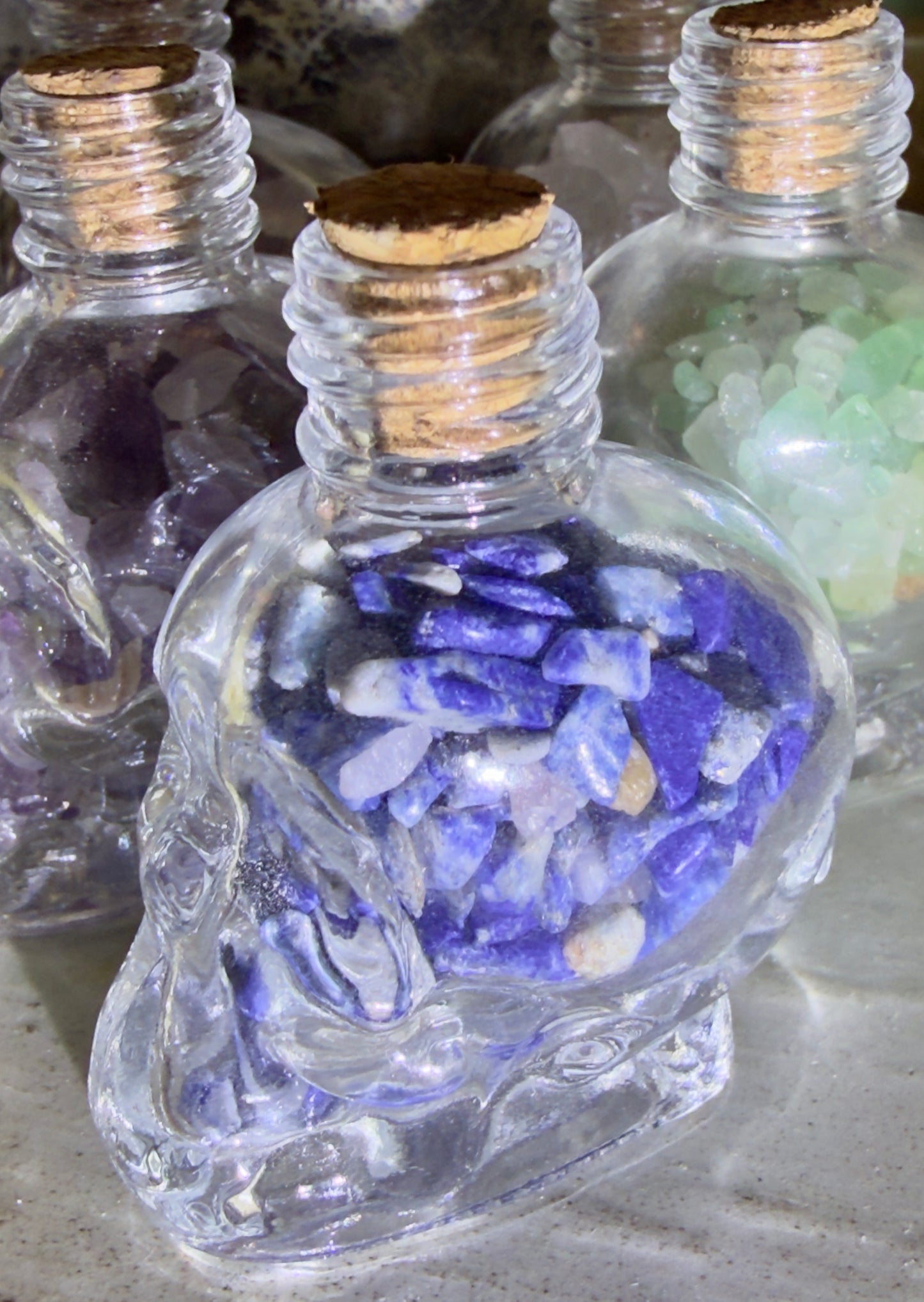 Sodalite crystal chips in a glass skull shaped wish bottle