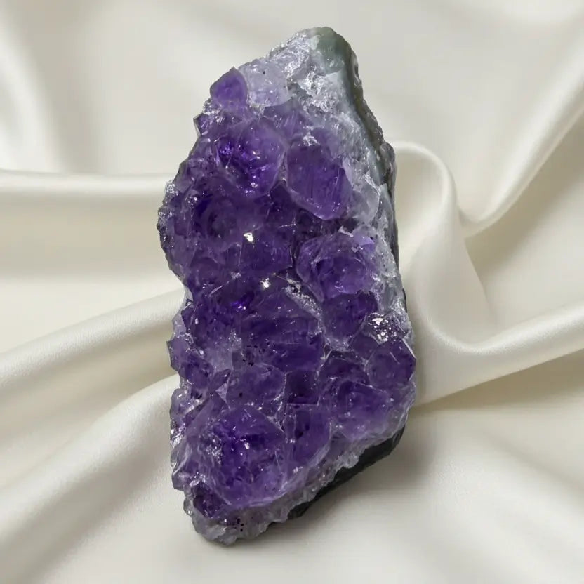 A raw purple amethyst crystal cluster with a rough natural shape