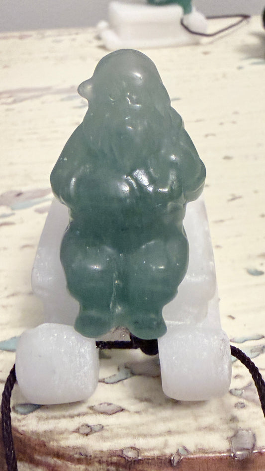 Green jade figure on a white base with a blurred background