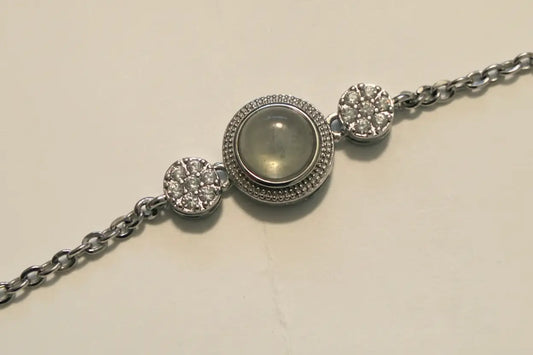 Silver bracelet with a central gemstone on a light beige background