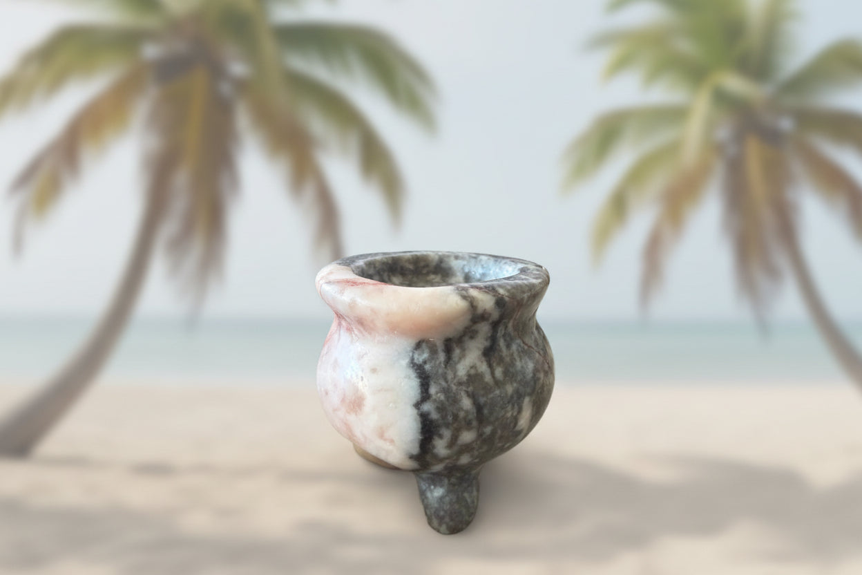 Zebra marble crystal carved into a small cauldron with palm trees behind