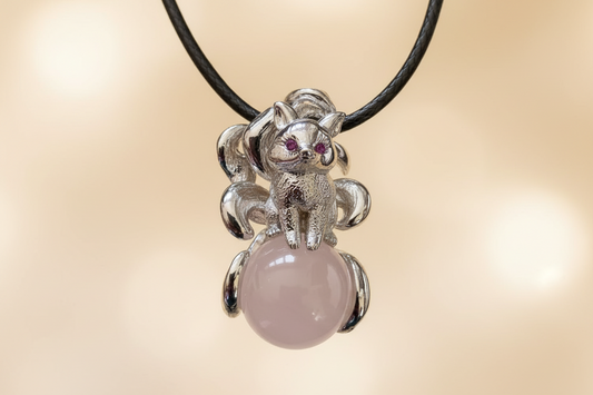 silver 9 tail ox on a rose quartz pendant with a waxed leather cord eyes are crystal chips