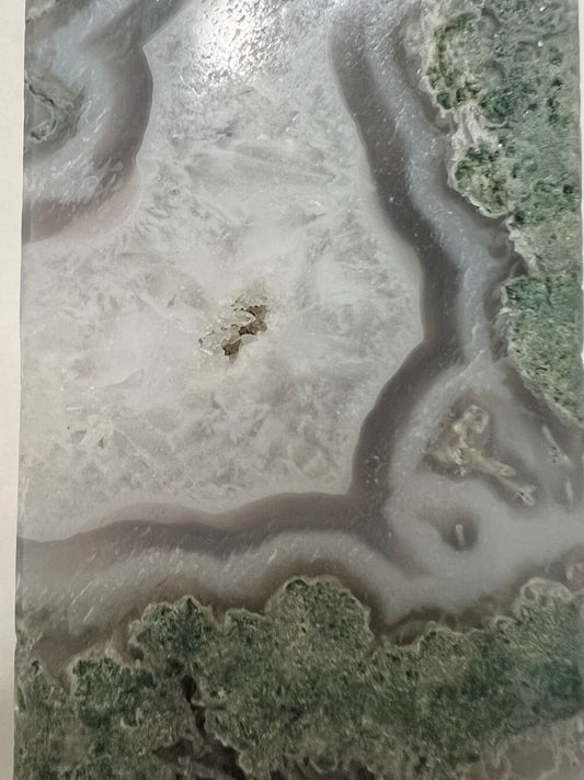 Cut and polished moss agate slab with white, gray, and green tones.