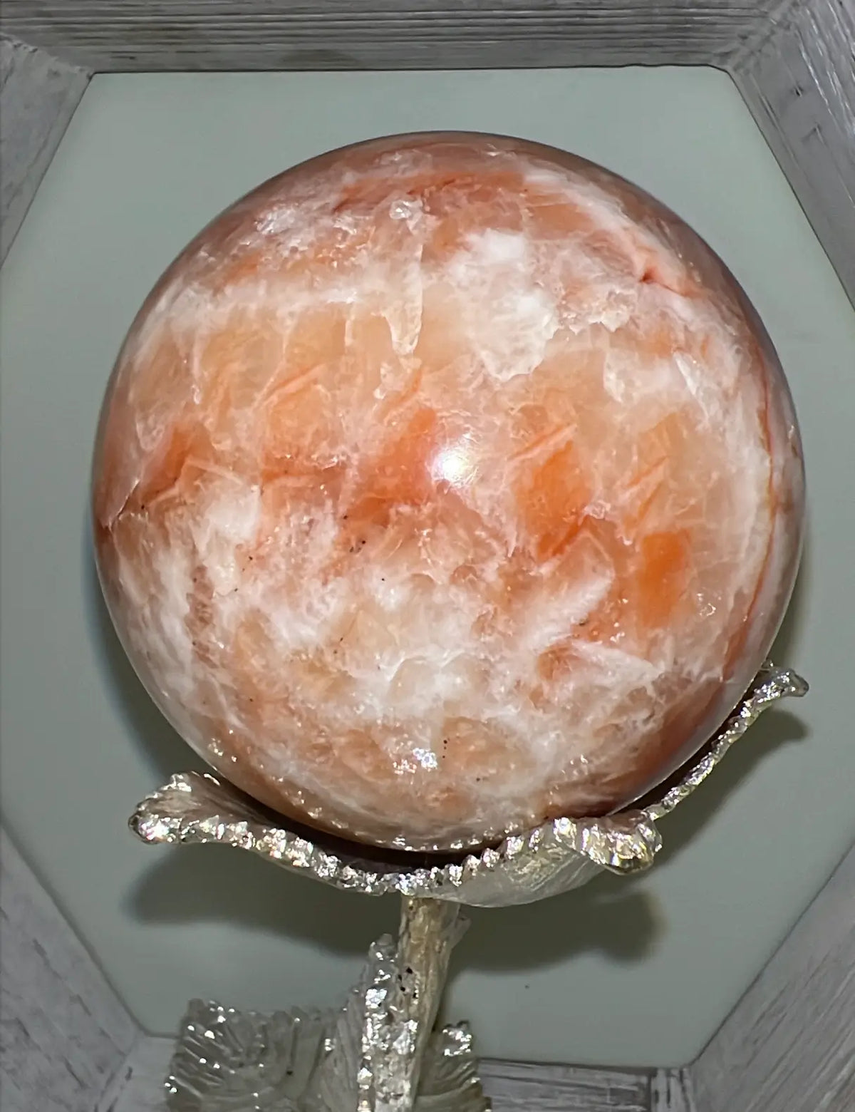 Large Orange Calcite sphere on silver floral stand