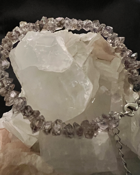 Silver amethyst bracelet on a white quartz crystal.