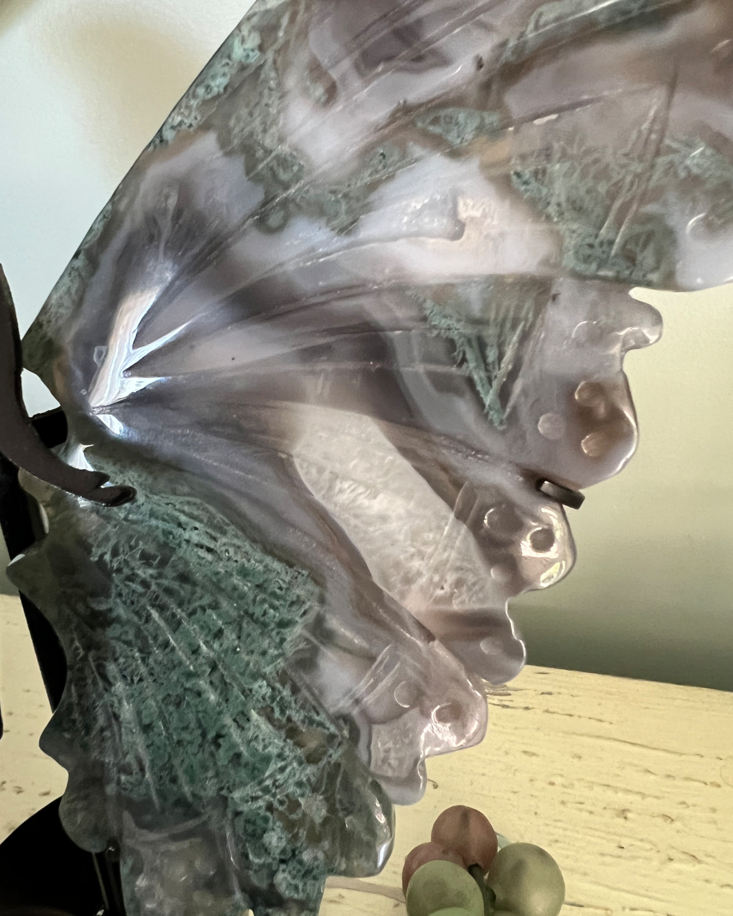 Close-up of a carved butterfly wing made of moss agate.
