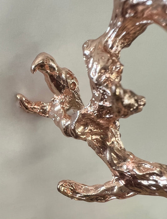 Close-up of a textured, rose gold branch.