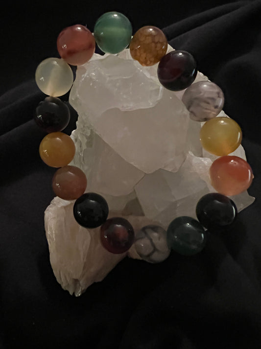 A beaded bracelet on a piece of crystal against a dark background.