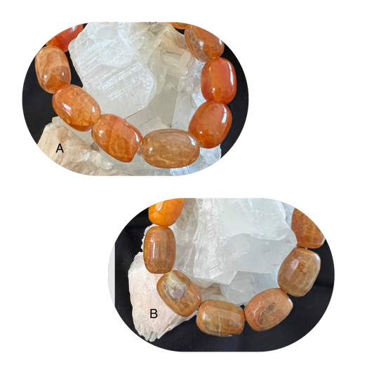 Two bracelets made of polished, orange-brown stones. A rests atop white crystals, while B is below.
