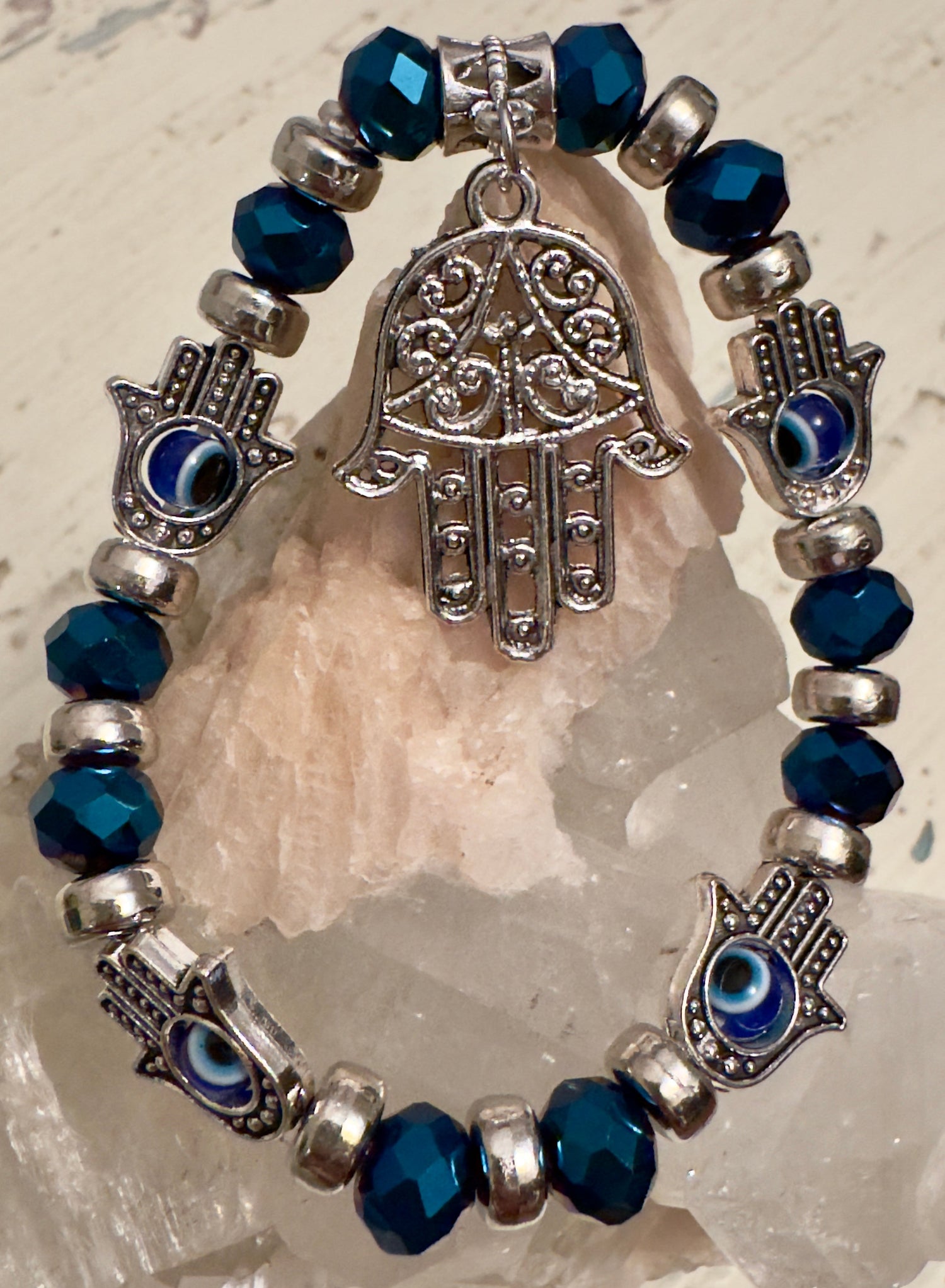 close up of crystal bracelet with hamsa hand and evil for protection 
