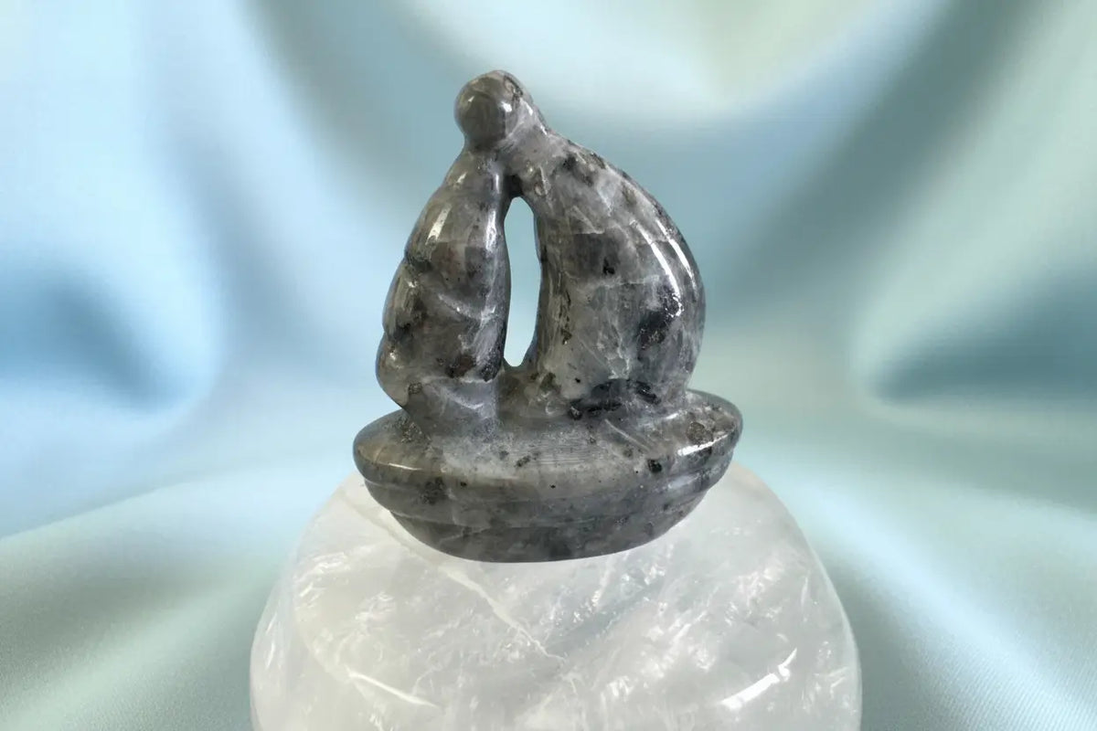 Larvikite crystal sailboat carving on Clear Quartz display bowl