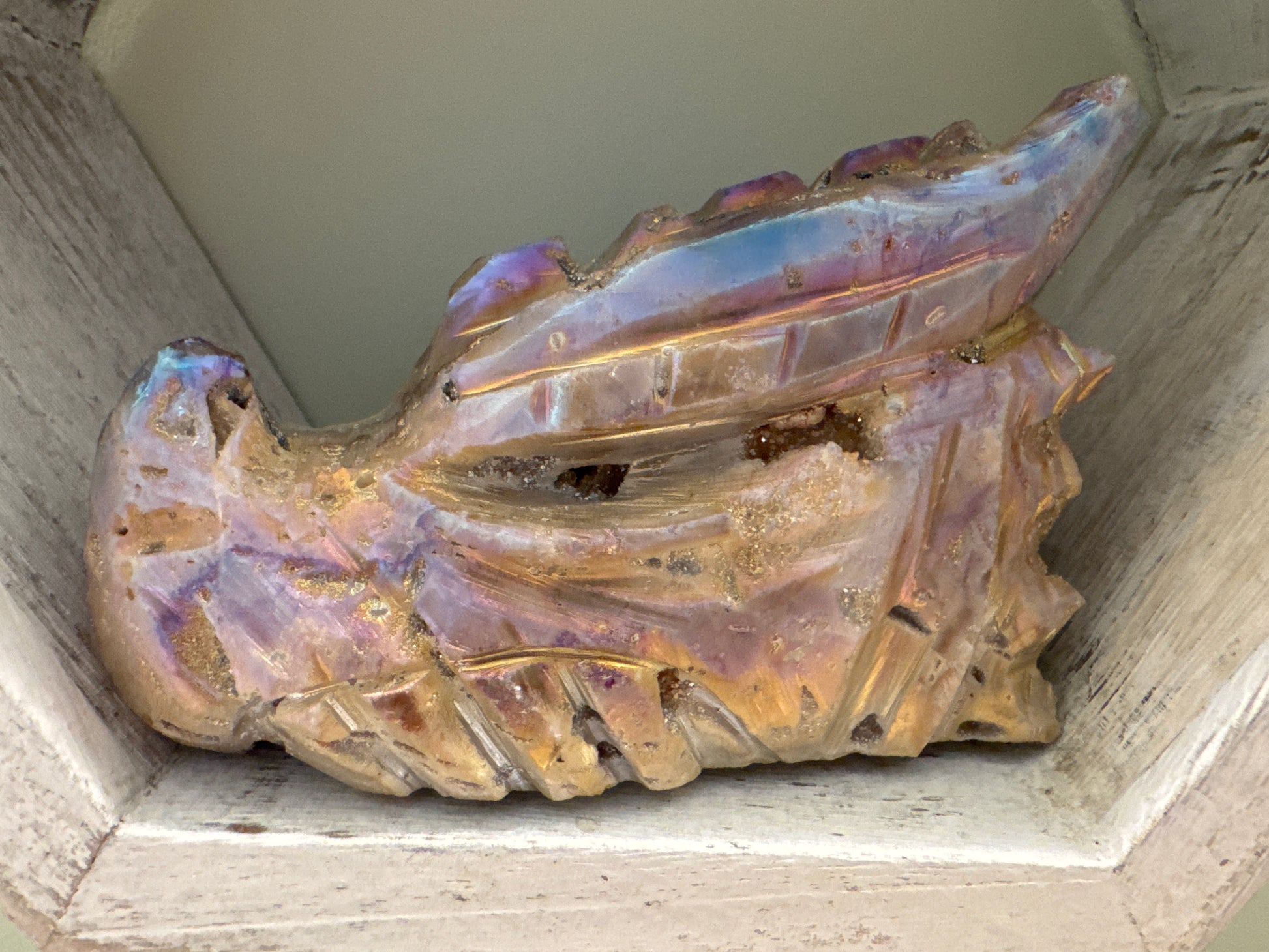 Iridescent quartz dragon figurine in a wooden display case.