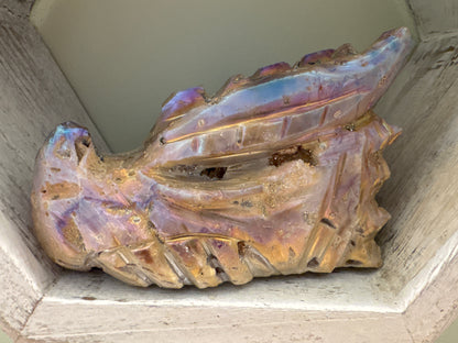 Iridescent quartz dragon figurine in a wooden display case.