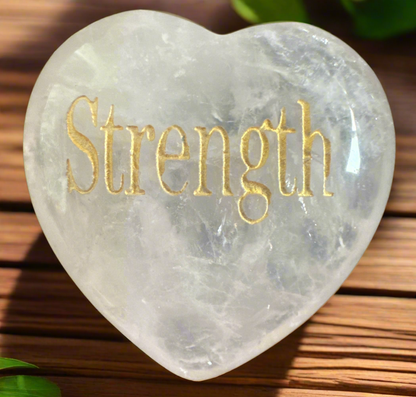 A heart-shaped crystal with "Strength" engraved in gold.