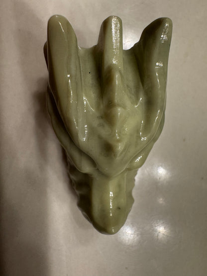 A glossy green statue of a dragon head.
