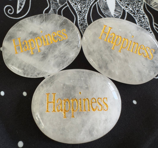 Three white quartz stones with "Happiness" in gold lettering.