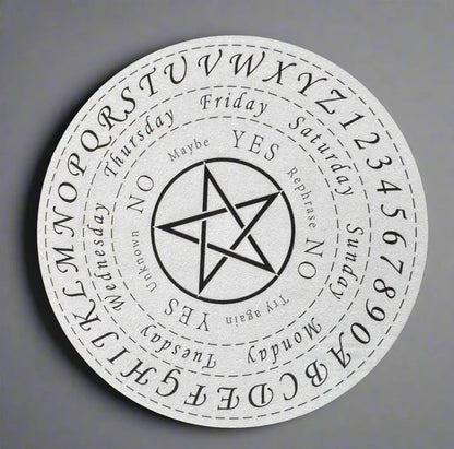 White spirit board with black markings, letters, numbers, days of the week, and a pentagram in the center.