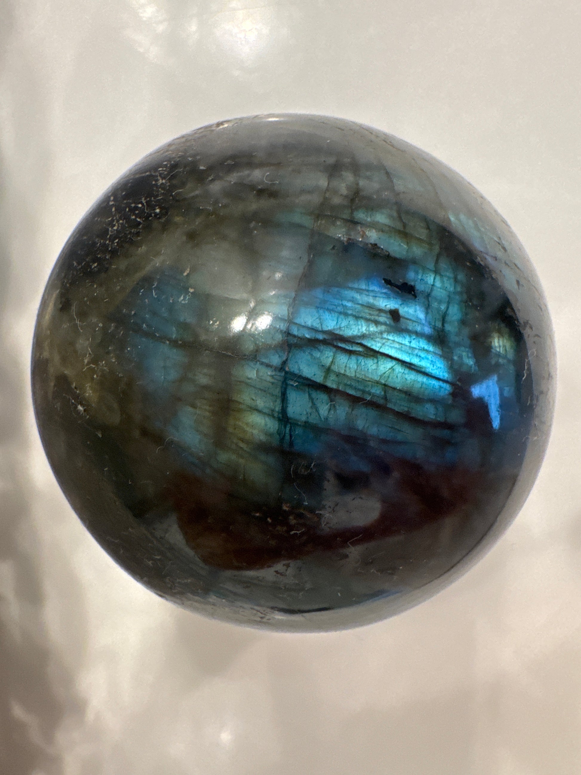 Labradorite sphere showing blue and green iridescence.