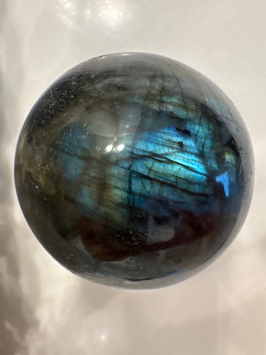 Labradorite sphere showing blue and green iridescence.